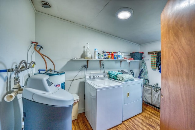 laundry room featuring water heater, laundry area, light wood finished floors, and washing machine and dryer