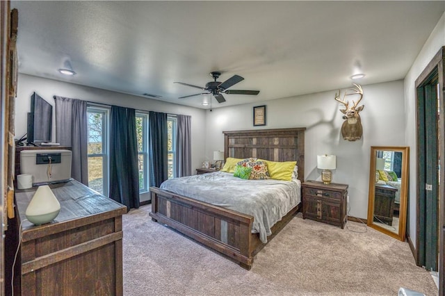 bedroom featuring ceiling fan, visible vents, and light colored carpet