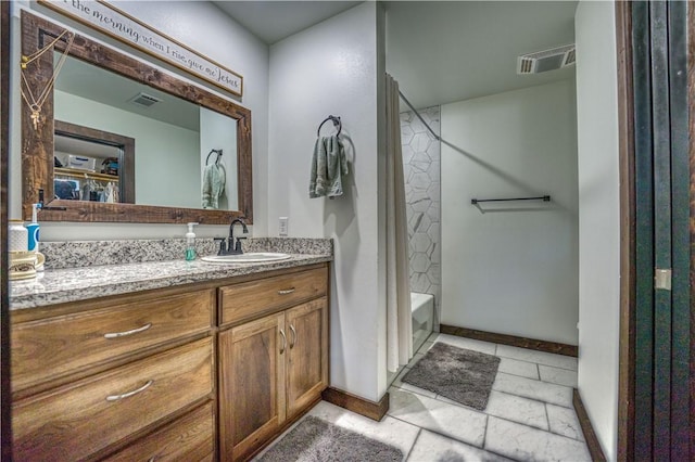 full bath with visible vents, vanity, baseboards, and bathing tub / shower combination