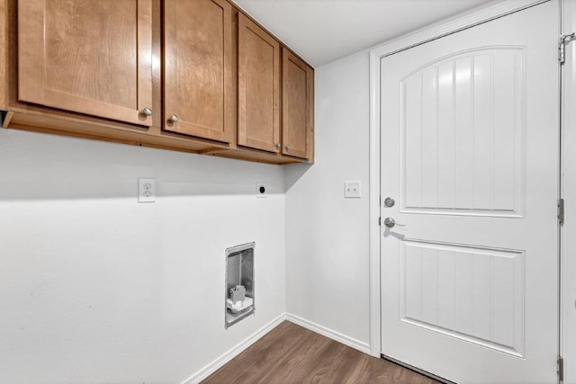 clothes washing area with cabinet space, electric dryer hookup, dark wood-type flooring, and baseboards