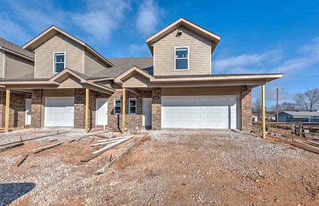 view of front of property with brick siding, a garage, and driveway