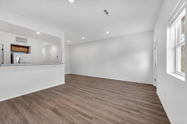 unfurnished living room featuring visible vents, recessed lighting, baseboards, and wood finished floors