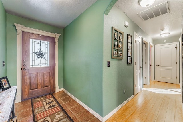 foyer entrance featuring dark hardwood / wood-style floors and a textured ceiling