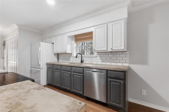 kitchen with white refrigerator, tasteful backsplash, stainless steel dishwasher, and white cabinetry