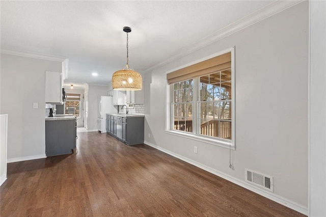 unfurnished dining area featuring dark hardwood / wood-style flooring, crown molding, and sink