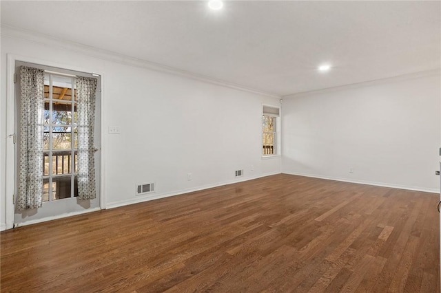 empty room with hardwood / wood-style floors and crown molding