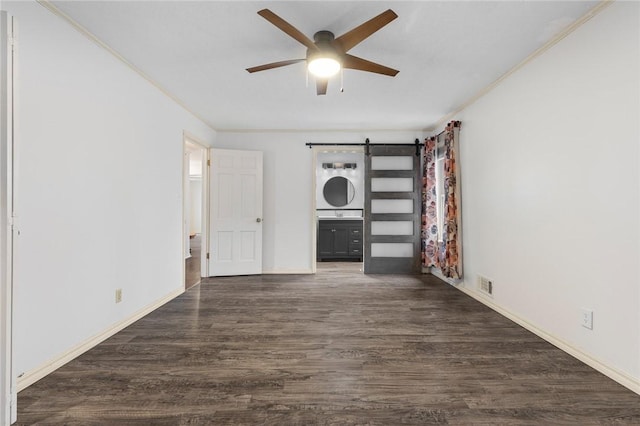 interior space featuring a barn door, ceiling fan, dark hardwood / wood-style flooring, and ornamental molding