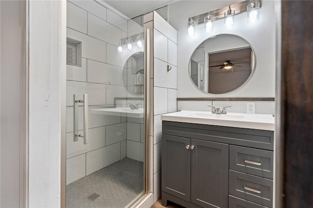 bathroom featuring ceiling fan, vanity, and walk in shower