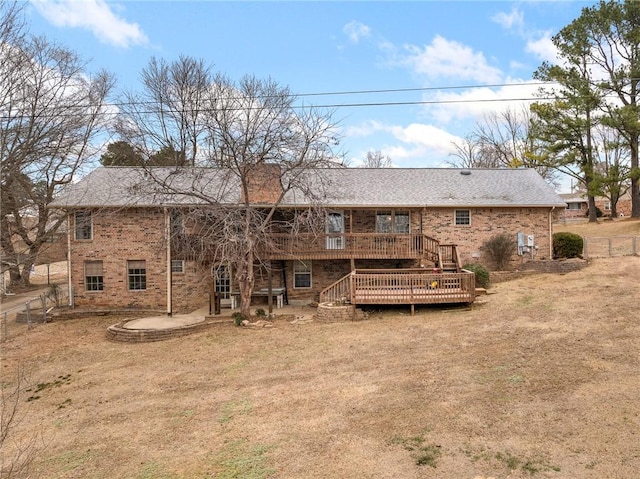 rear view of property featuring a lawn, a patio area, and a wooden deck