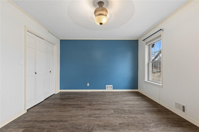 unfurnished bedroom with dark hardwood / wood-style flooring, a closet, and ceiling fan