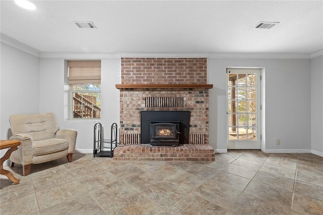 living room featuring a brick fireplace, plenty of natural light, and crown molding