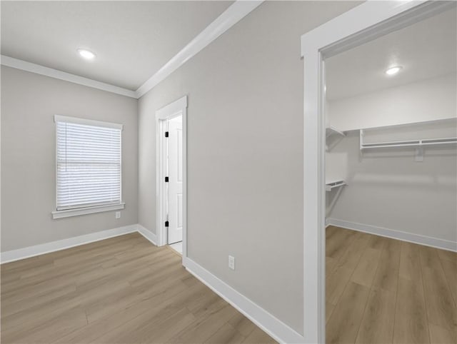 hallway with light hardwood / wood-style flooring and ornamental molding