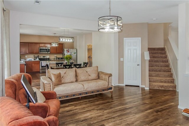 living room featuring dark wood-type flooring and a chandelier