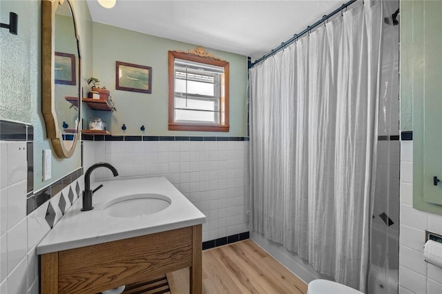 full bathroom featuring shower / bathtub combination with curtain, toilet, vanity, tile walls, and hardwood / wood-style flooring