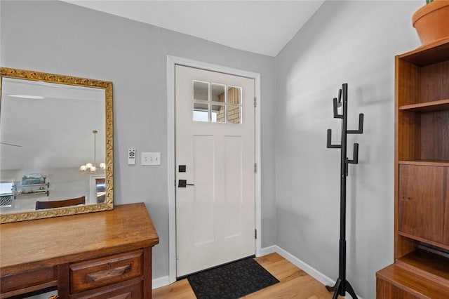 foyer with light hardwood / wood-style floors and an inviting chandelier