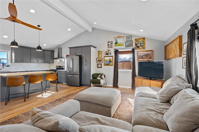 living room with vaulted ceiling with beams and light hardwood / wood-style flooring