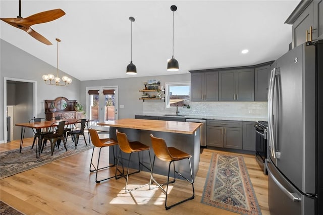 kitchen with decorative light fixtures, sink, stainless steel appliances, and tasteful backsplash