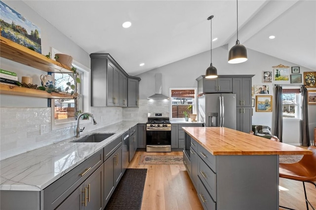 kitchen with wall chimney range hood, sink, decorative backsplash, gray cabinets, and stainless steel appliances