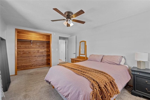 bedroom with ceiling fan, light colored carpet, and a closet