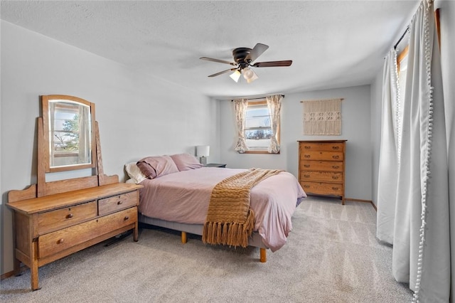 carpeted bedroom featuring multiple windows, ceiling fan, and a textured ceiling