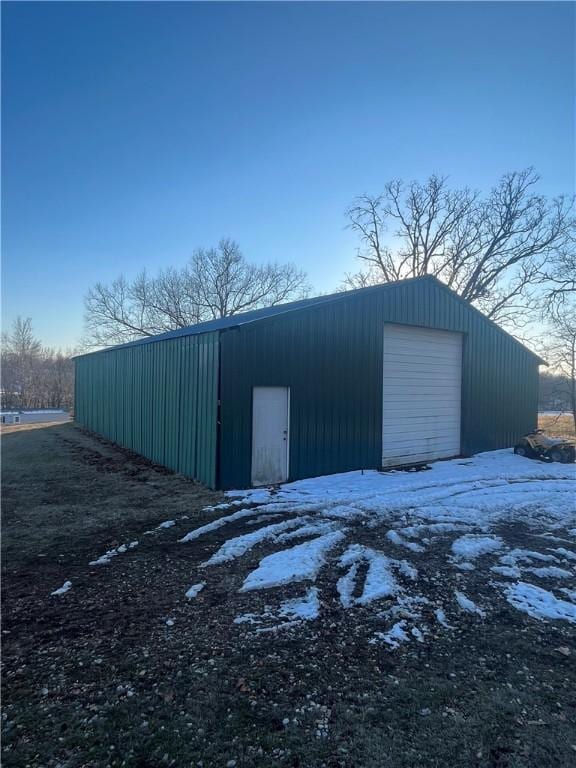 snow covered structure featuring a garage