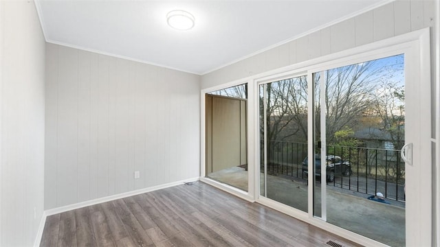 spare room featuring hardwood / wood-style flooring and ornamental molding