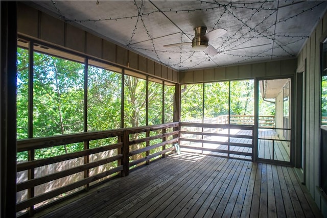 unfurnished sunroom featuring ceiling fan