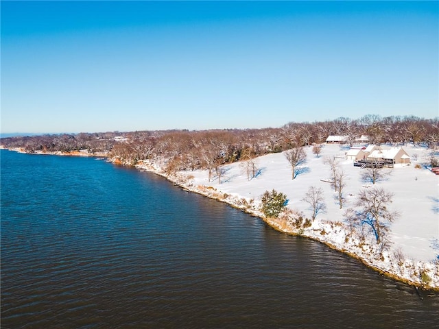 snowy aerial view featuring a water view