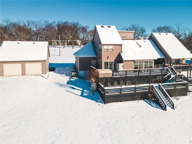 snow covered back of property with a garage