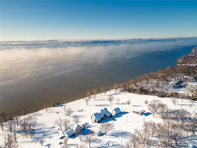 snowy aerial view featuring a water view