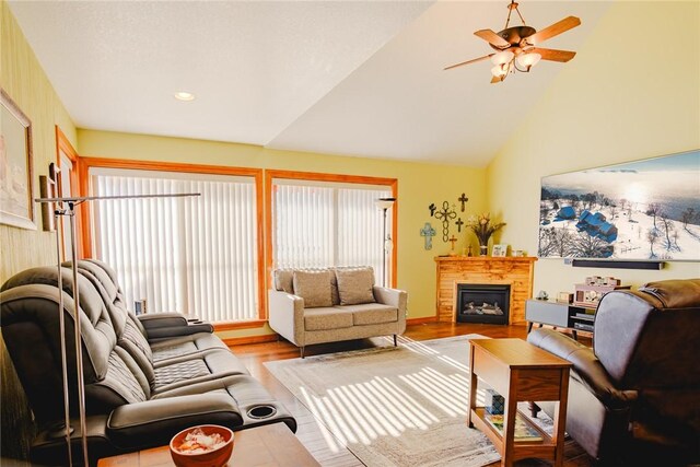 living room featuring ceiling fan, light hardwood / wood-style flooring, and lofted ceiling