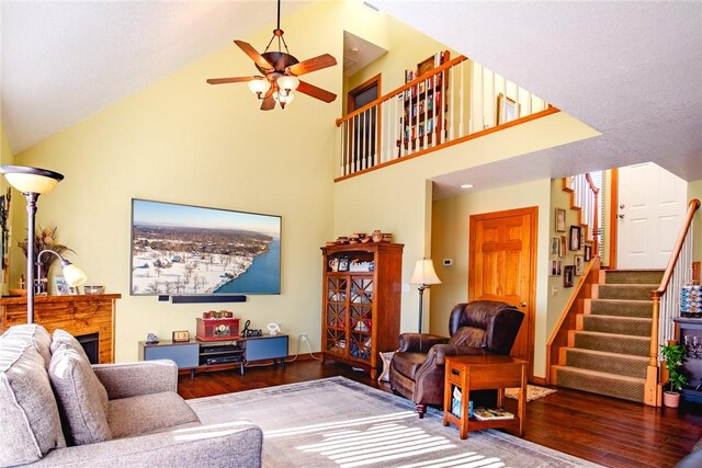 living room featuring ceiling fan, dark hardwood / wood-style flooring, and high vaulted ceiling