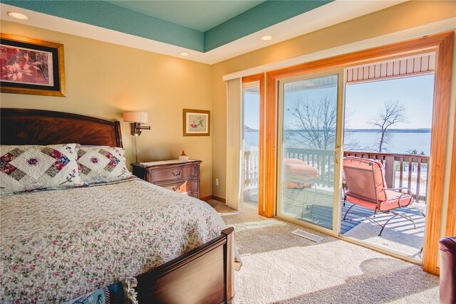 bedroom with a water view, access to exterior, and carpet