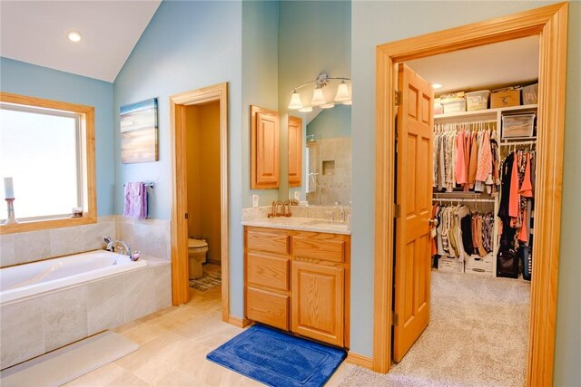 full bathroom with separate shower and tub, vaulted ceiling, vanity, and toilet