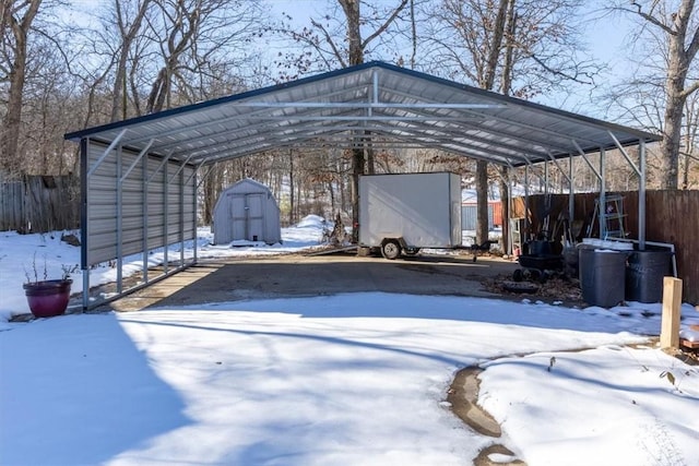 snow covered parking with a carport