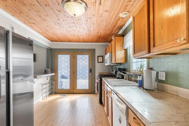 kitchen featuring light hardwood / wood-style flooring, wood ceiling, appliances with stainless steel finishes, ornamental molding, and sink