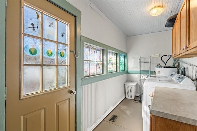 clothes washing area featuring independent washer and dryer, cabinets, and gas water heater