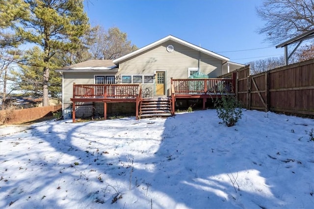 snow covered property with a wooden deck