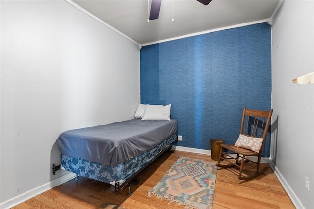 bedroom featuring hardwood / wood-style flooring, ornamental molding, and ceiling fan