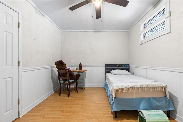 bedroom with ceiling fan, crown molding, and hardwood / wood-style floors