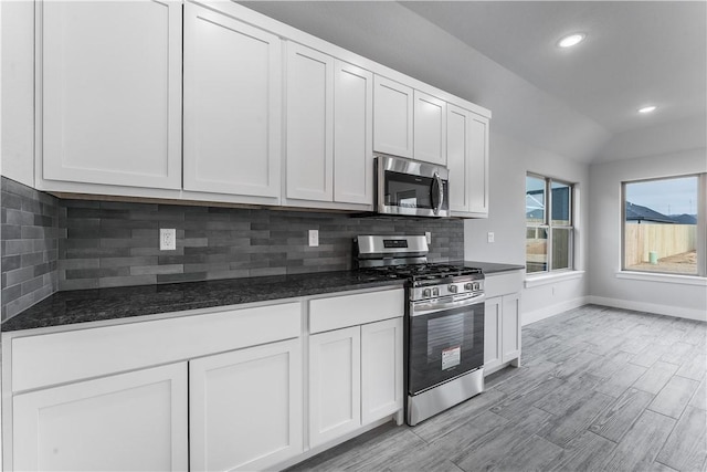 kitchen featuring white cabinets, backsplash, and appliances with stainless steel finishes