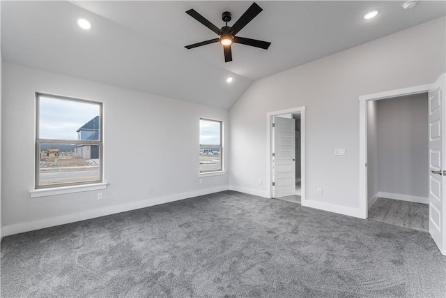 unfurnished bedroom featuring vaulted ceiling, a walk in closet, carpet floors, and ceiling fan