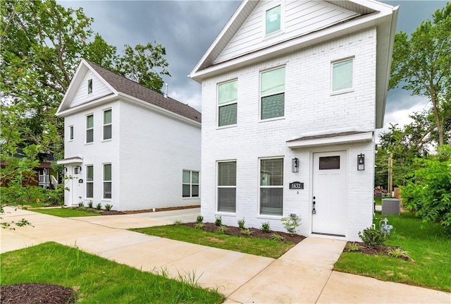 front of property featuring cooling unit and a front lawn