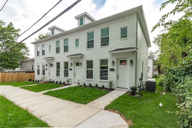 view of front of home featuring cooling unit and a front lawn