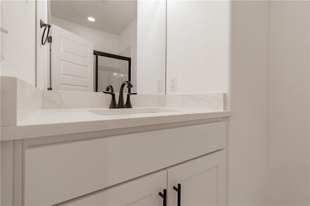 bathroom with vanity and a shower with shower door