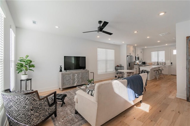 living room featuring ceiling fan and light wood-type flooring