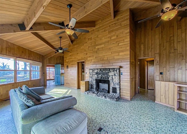 living room with high vaulted ceiling, wooden walls, a fireplace, and beamed ceiling