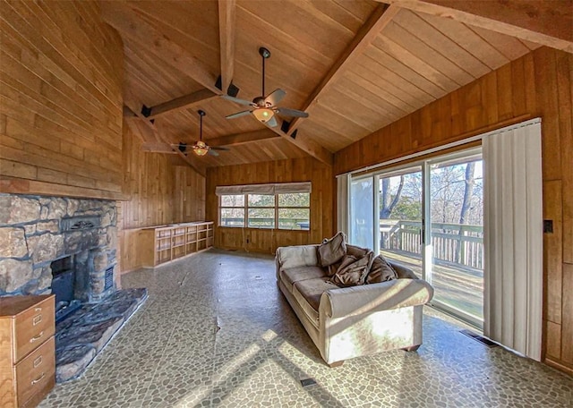 unfurnished living room with ceiling fan, high vaulted ceiling, beam ceiling, and wooden walls