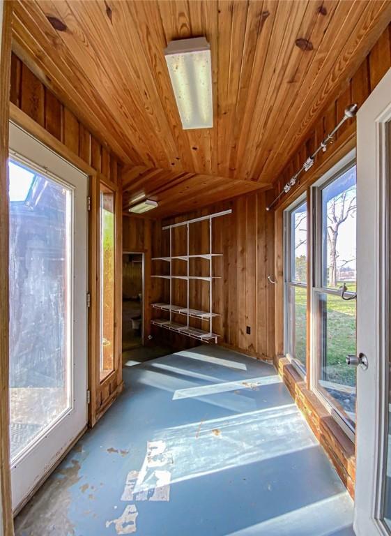 unfurnished sunroom with a healthy amount of sunlight, wood ceiling, and lofted ceiling