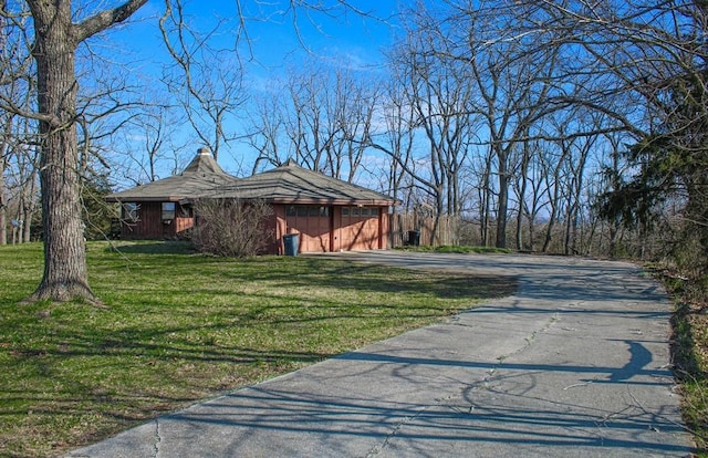 view of side of home with a garage and a lawn